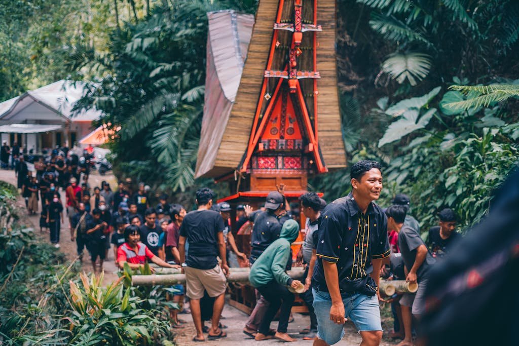 A vibrant traditional funeral procession with ornate casket carried through a tropical forest, showcasing cultural heritage.