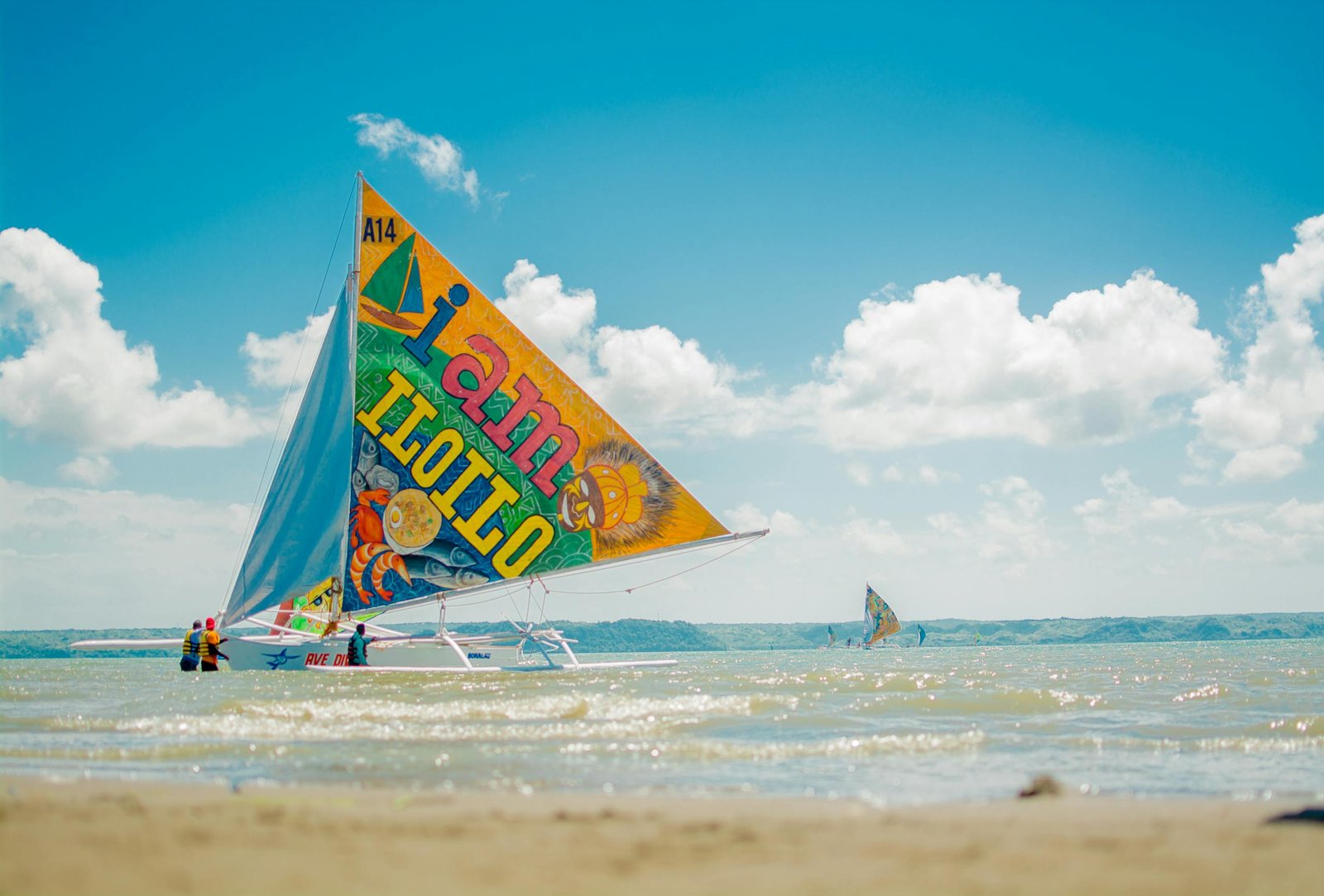 Colorful sailboat on the beach in Iloilo City, Philippines under clear skies.