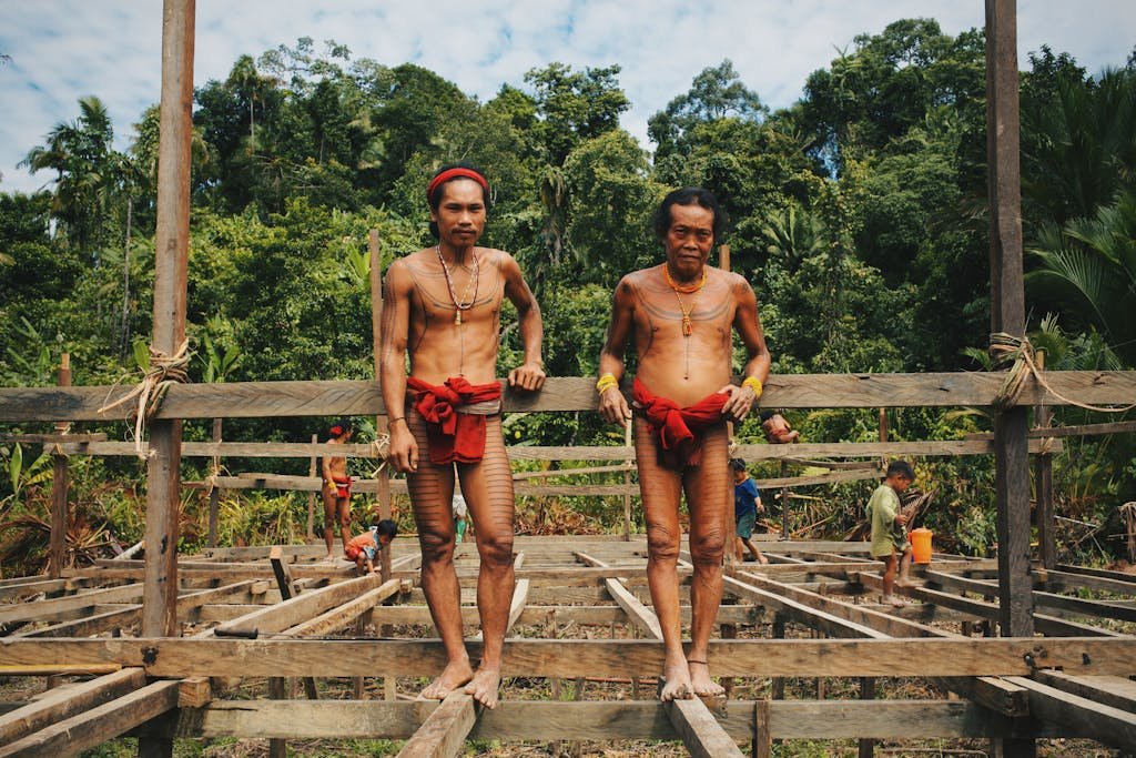 Mentawai tribe members constructing a traditional wooden structure in West Sumatra, Indonesia.